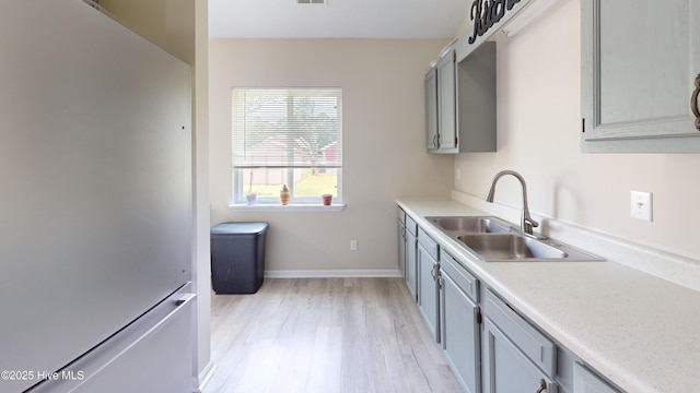 973 Ramsey Rd, Jacksonville, NC 28546 - kitchen with freestanding refrigerator, light wood-style floors, light countertops, and gray cabinets