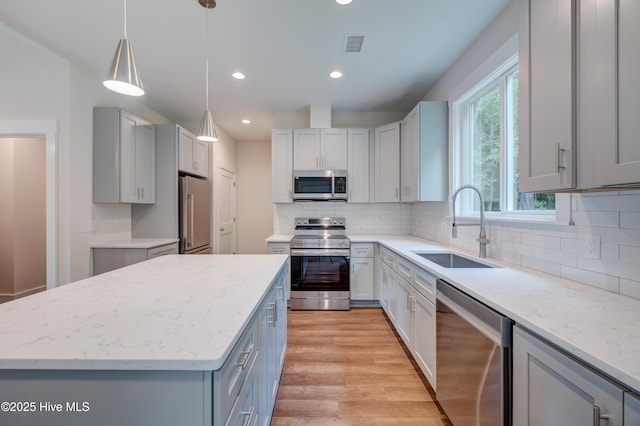 1536 Dorsey Ln, Navassa, NC 28451 - kitchen with appliances with stainless steel finishes, recessed lighting, light wood finished floors, a kitchen island, and gray cabinets