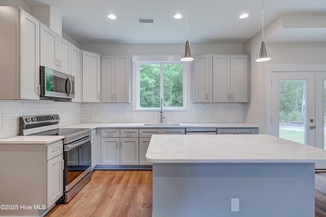 1536 Dorsey Ln, Navassa, NC 28451 - kitchen with appliances with stainless steel finishes, recessed lighting, backsplash, light stone countertops, and decorative light fixtures