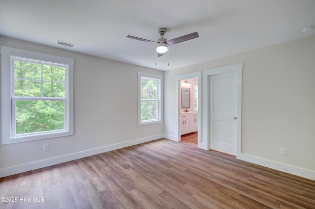 1536 Dorsey Ln, Navassa, NC 28451 - unfurnished bedroom with wood finished floors, ensuite bathroom, and ceiling fan