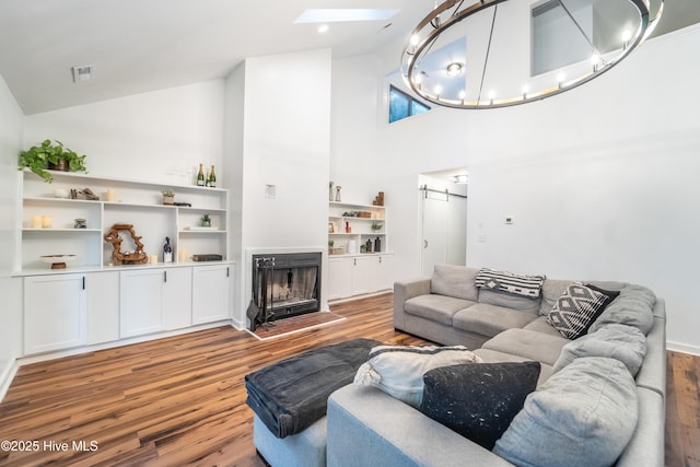 6017 Covenant Ln, Wilmington, NC 28403 - living area with wood finished floors, a skylight, high vaulted ceiling, and a fireplace with flush hearth