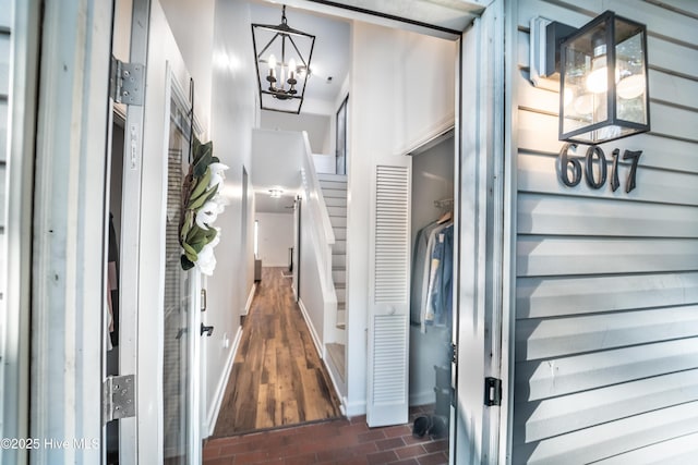 6017 Covenant Ln, Wilmington, NC 28403 - hallway featuring a chandelier, brick patterned flooring, and stairway