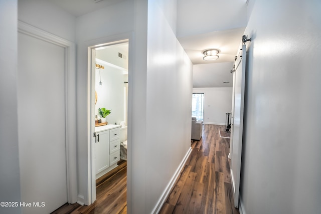 6017 Covenant Ln, Wilmington, NC 28403 - corridor featuring a barn door and dark wood-type flooring