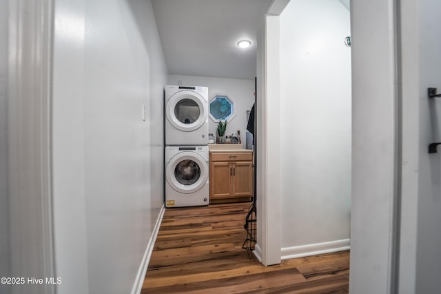 6017 Covenant Ln, Wilmington, NC 28403 - washroom featuring stacked washing machine and dryer, cabinet space, and wood finished floors