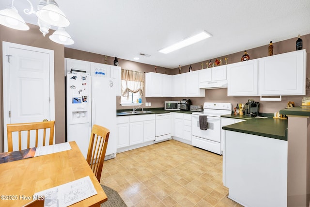 529 Maple Branches Dr, Leland, NC 28451 - kitchen with white appliances, under cabinet range hood, dark countertops, white cabinetry, and light floors