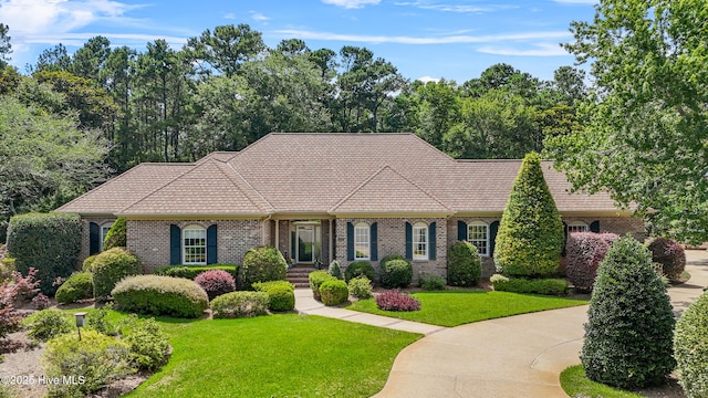 2000 Marsh Harbor Pl, Wilmington, NC 28405 - view of front of home featuring brick siding, a front lawn, and a tile roof