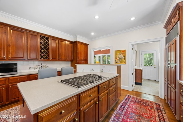 2000 Marsh Harbor Pl, Wilmington, NC 28405 - kitchen featuring appliances with stainless steel finishes, healthy amount of natural light, light countertops, a center island, and ornamental molding