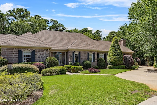 2000 Marsh Harbor Pl, Wilmington, NC 28405 - view of front of house featuring a front lawn, brick siding, and a chimney