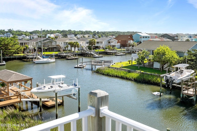 130 Raleigh St, Holden Beach, NC 28462 - dock featuring boat lift, a residential view, and a water view