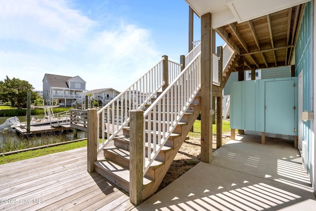 130 Raleigh St, Holden Beach, NC 28462 - wooden deck featuring stairway, a water view, and a boat dock