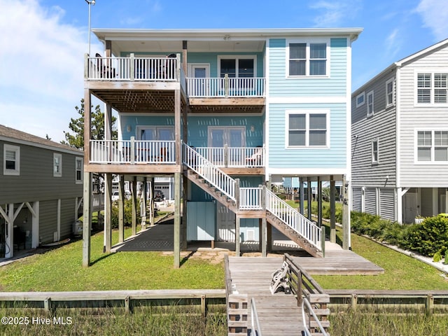 130 Raleigh St, Holden Beach, NC 28462 - back of property with a balcony and a lawn
