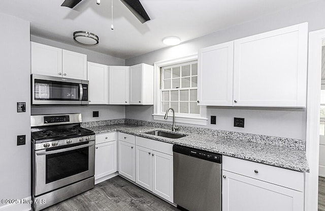 309 Mcgwigan St, Enfield, NC 27823 - kitchen with stainless steel appliances, dark wood-style flooring, white cabinetry, and light stone countertops