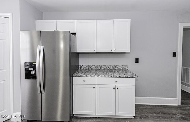 309 Mcgwigan St, Enfield, NC 27823 - kitchen with stainless steel fridge with ice dispenser, white cabinetry, light stone counters, and dark wood-type flooring