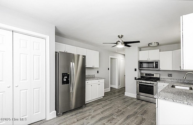 309 Mcgwigan St, Enfield, NC 27823 - kitchen featuring appliances with stainless steel finishes, a ceiling fan, white cabinets, and light stone countertops