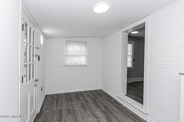 309 Mcgwigan St, Enfield, NC 27823 - empty room with brick wall, plenty of natural light, and dark wood-type flooring