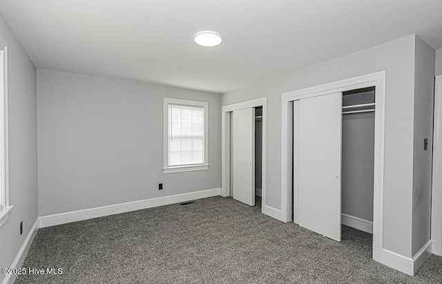 309 Mcgwigan St, Enfield, NC 27823 - unfurnished bedroom featuring two closets and dark colored carpet