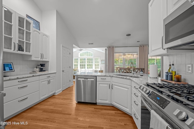 118 Tremayne Dr, New Bern, NC 28560 - kitchen with stainless steel appliances, white cabinets, backsplash, light wood-style floors, and vaulted ceiling