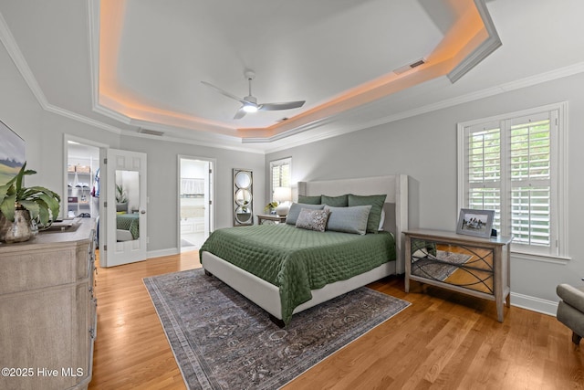118 Tremayne Dr, New Bern, NC 28560 - bedroom featuring a tray ceiling, crown molding, light wood-style floors, ceiling fan, and connected bathroom