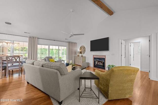 118 Tremayne Dr, New Bern, NC 28560 - living area featuring a tile fireplace, beam ceiling, light wood finished floors, ceiling fan, and a chandelier