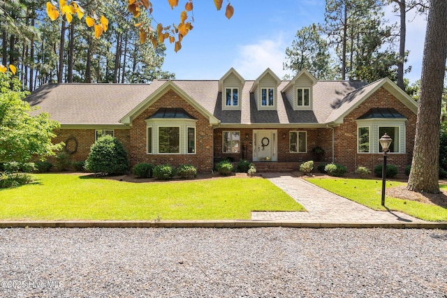 15 Magnolia Ave, Pinehurst, NC 28374 - view of front facade with brick siding, a shingled roof, and a front yard
