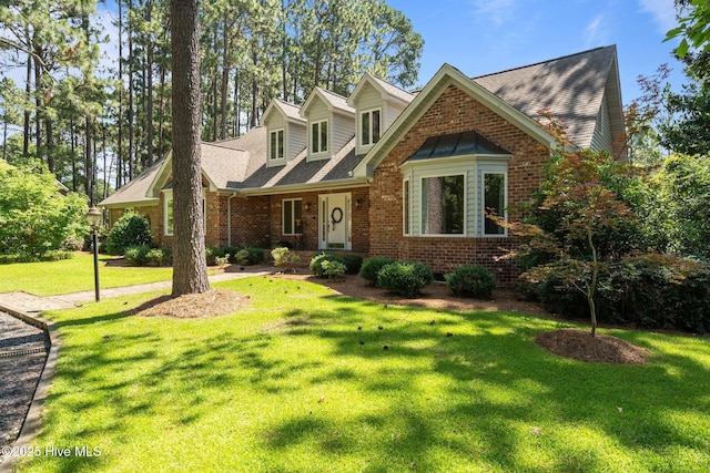 15 Magnolia Ave, Pinehurst, NC 28374 - view of front of property featuring brick siding, a front yard, and roof with shingles