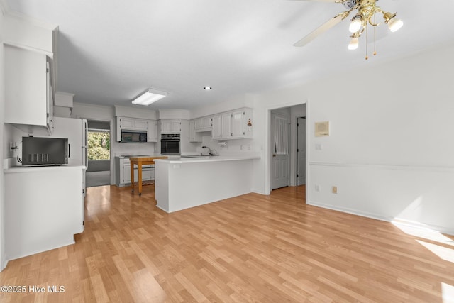 15 Magnolia Ave, Pinehurst, NC 28374 - kitchen with oven, a peninsula, stainless steel microwave, and light wood-style flooring