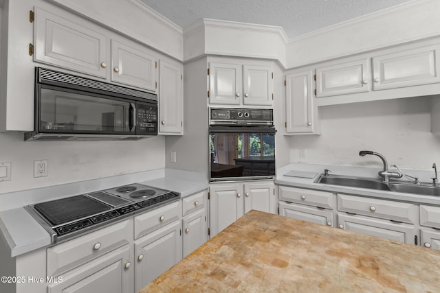 15 Magnolia Ave, Pinehurst, NC 28374 - kitchen featuring black appliances, light countertops, crown molding, white cabinetry, and a textured ceiling