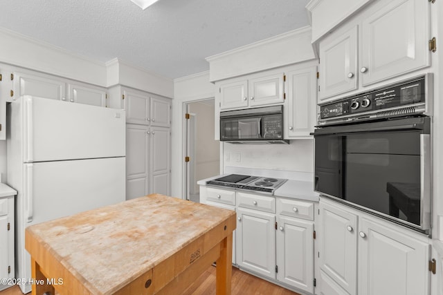 15 Magnolia Ave, Pinehurst, NC 28374 - kitchen featuring black appliances, crown molding, light countertops, a textured ceiling, and white cabinets