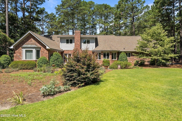 15 Magnolia Ave, Pinehurst, NC 28374 - traditional-style home with brick siding, a chimney, and a front yard