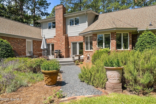 15 Magnolia Ave, Pinehurst, NC 28374 - rear view of property with a chimney, brick siding, a shingled roof, and a deck