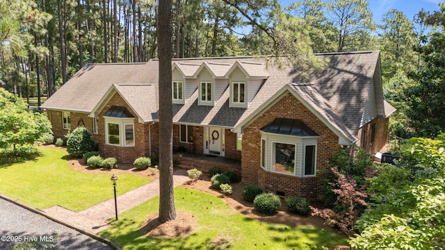 15 Magnolia Ave, Pinehurst, NC 28374 - view of front of property featuring a front lawn, brick siding, and roof with shingles