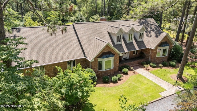 15 Magnolia Ave, Pinehurst, NC 28374 - view of front of house featuring brick siding, a front yard, and a chimney