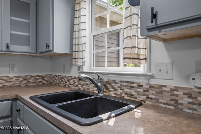 1134 Tebo Rd, New Bern, NC 28562 - kitchen with gray cabinetry, backsplash, glass insert cabinets, and dark countertops