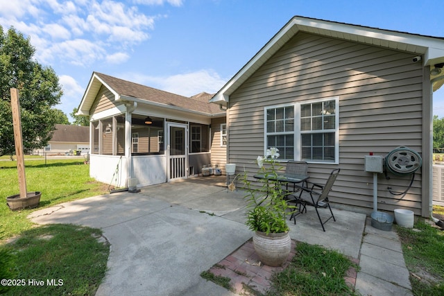 1134 Tebo Rd, New Bern, NC 28562 - rear view of house featuring a sunroom, a lawn, a patio area, and a shingled roof