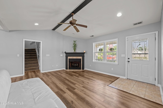 1134 Tebo Rd, New Bern, NC 28562 - unfurnished living room with stairs, wood finished floors, lofted ceiling, a ceiling fan, and a tile fireplace