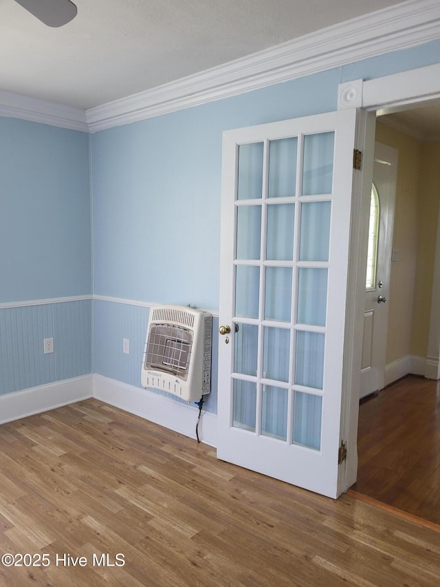 550 E Pungo St, Belhaven, NC 27810 - spare room featuring heating unit, wood finished floors, ornamental molding, and wainscoting