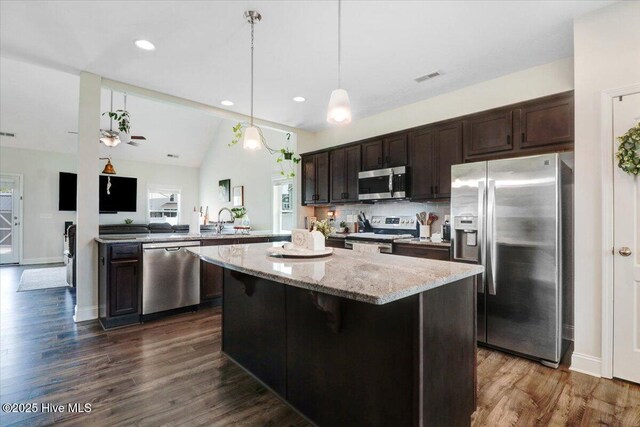108 Bernier Ct, Princeton, NC 27569 - kitchen with appliances with stainless steel finishes, dark brown cabinets, dark wood finished floors, light stone counters, and a center island