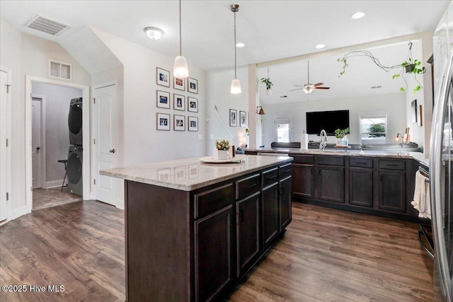 108 Bernier Ct, Princeton, NC 27569 - kitchen featuring stacked washing machine and dryer, a ceiling fan, dark wood-type flooring, light stone countertops, and recessed lighting