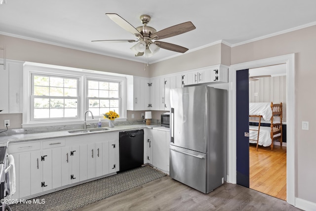 502 N 25th St, Wilmington, NC 28405 - kitchen with appliances with stainless steel finishes, a ceiling fan, light wood-style flooring, white cabinets, and ornamental molding