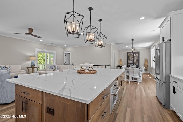 8805 Sound View Ct, Emerald Isle, NC 28594 - kitchen with stainless steel appliances, open floor plan, light wood finished floors, a center island, and a chandelier