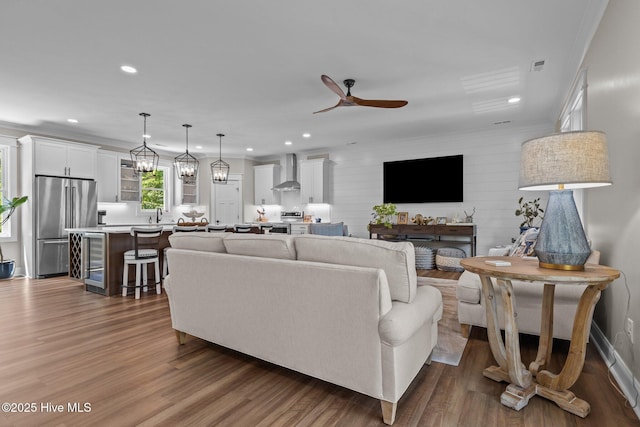 8805 Sound View Ct, Emerald Isle, NC 28594 - living room featuring ceiling fan, dark wood finished floors, recessed lighting, ornamental molding, and wine cooler