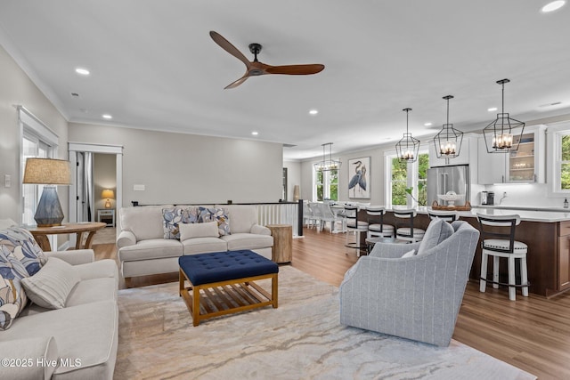 8805 Sound View Ct, Emerald Isle, NC 28594 - living room featuring recessed lighting, plenty of natural light, a ceiling fan, light wood-style flooring, and ornamental molding