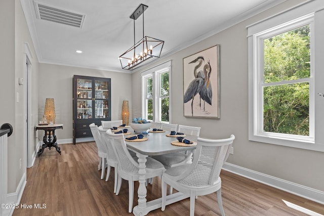 8805 Sound View Ct, Emerald Isle, NC 28594 - dining area with healthy amount of natural light, crown molding, wood finished floors, a chandelier, and recessed lighting