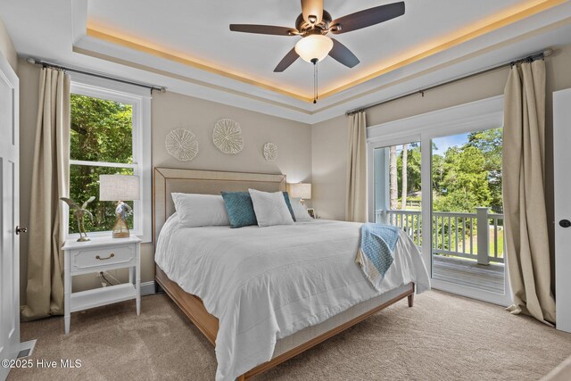 8805 Sound View Ct, Emerald Isle, NC 28594 - bedroom featuring a tray ceiling, access to exterior, carpet floors, and multiple windows