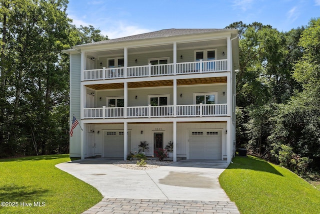 8805 Sound View Ct, Emerald Isle, NC 28594 - view of front of house featuring an attached garage, a front yard, driveway, a balcony, and board and batten siding