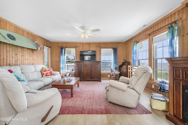 124 Holiday Knl, Hertford, NC 27944 - living room with wooden walls, wood finished floors, ceiling fan, and a fireplace
