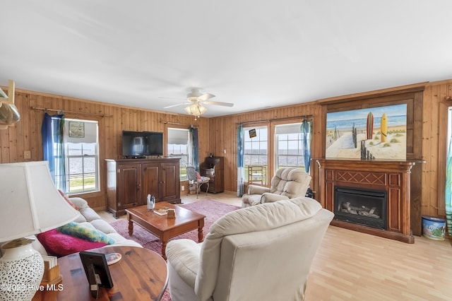 124 Holiday Knl, Hertford, NC 27944 - living area with wood walls, a fireplace, ceiling fan, and light wood-style floors