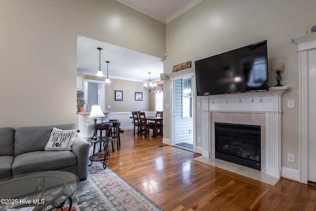 404 River Birch Dr, Greenville, NC 27858 - living area with crown molding, wood finished floors, a premium fireplace, a chandelier, and a towering ceiling