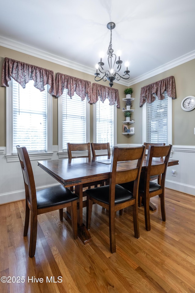 404 River Birch Dr, Greenville, NC 27858 - dining space with a chandelier, ornamental molding, light wood-type flooring, and a wainscoted wall