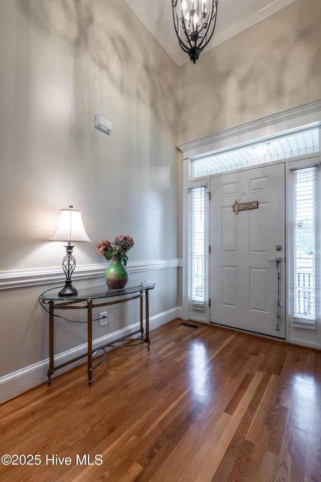 404 River Birch Dr, Greenville, NC 27858 - foyer entrance featuring a chandelier, plenty of natural light, ornamental molding, and wood finished floors